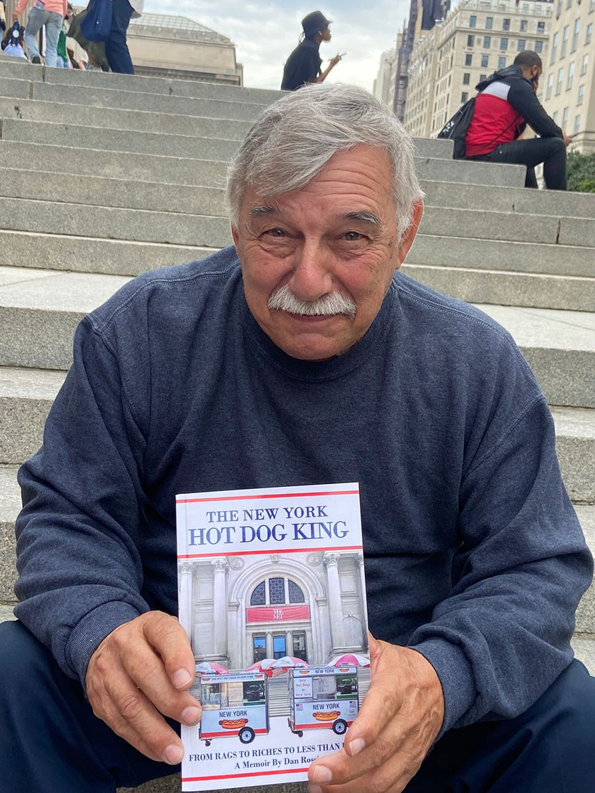 Dan holding a copy of "The New York Hot Dog King: From Rags to Riches to Less Than Rags"